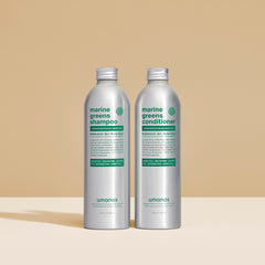 A pair of refillable and eco-friendly bottles full of Umanos marine greens shampoo and conditioner. All natural ingredients in sustainable bottles.
